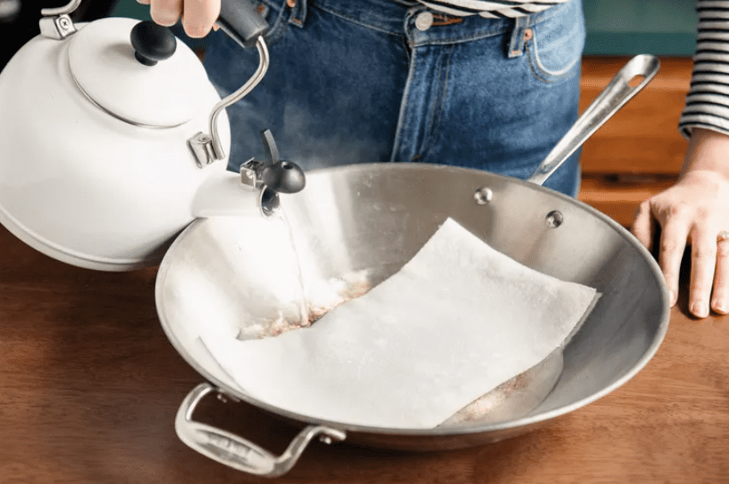 Cách Tẩy Vết Ố Trên Thép Không Gỉ 4 Đổ nước nóng lên khăn